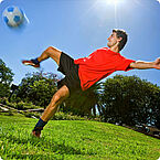Fussballer kickt auf grünen Rasen